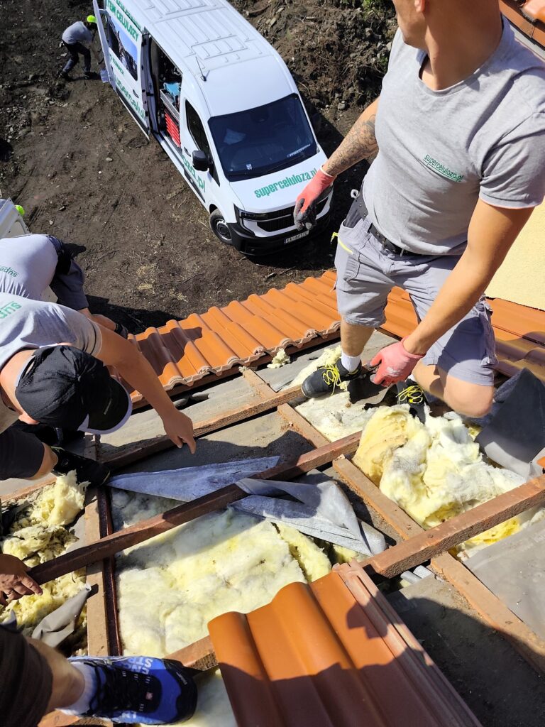 Usuwanie zniszczonej izolacji z wełny podczas naprawy dachu po kunach w Warszawie