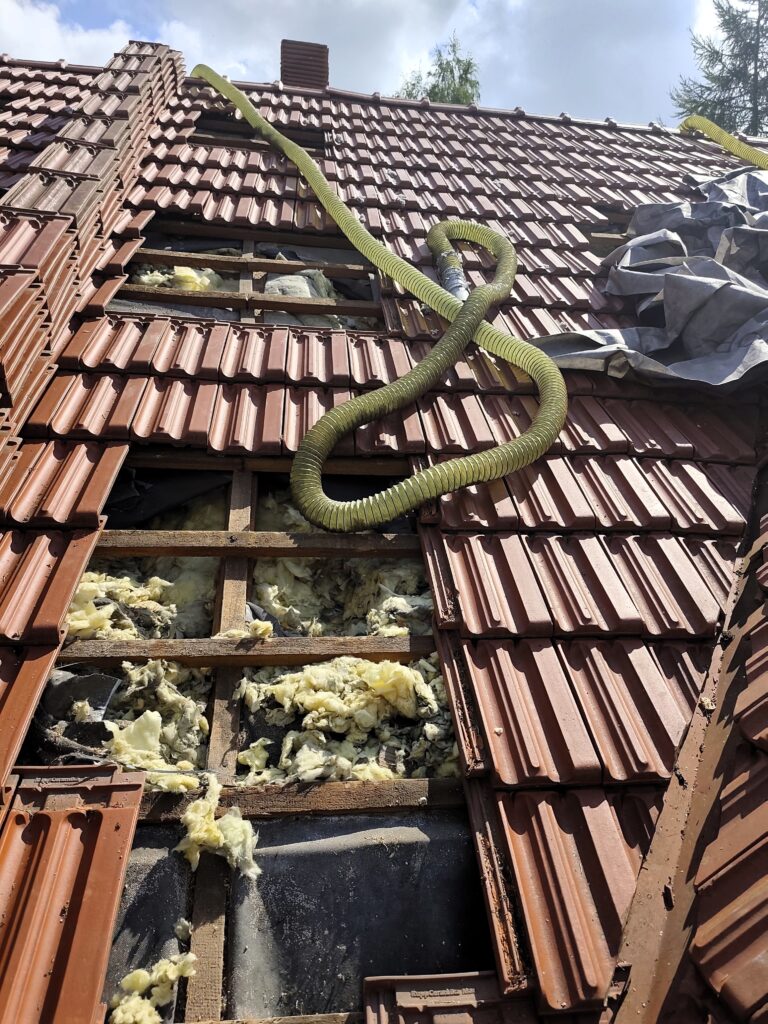 Naprawa dachu po kunie w Warszawie – zniszczona wełna mineralna na poddaszu